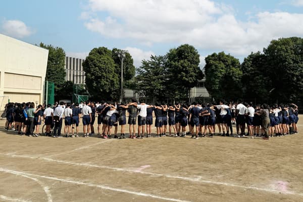 運動会前に全校生徒と教員で円陣を組んでいる様子